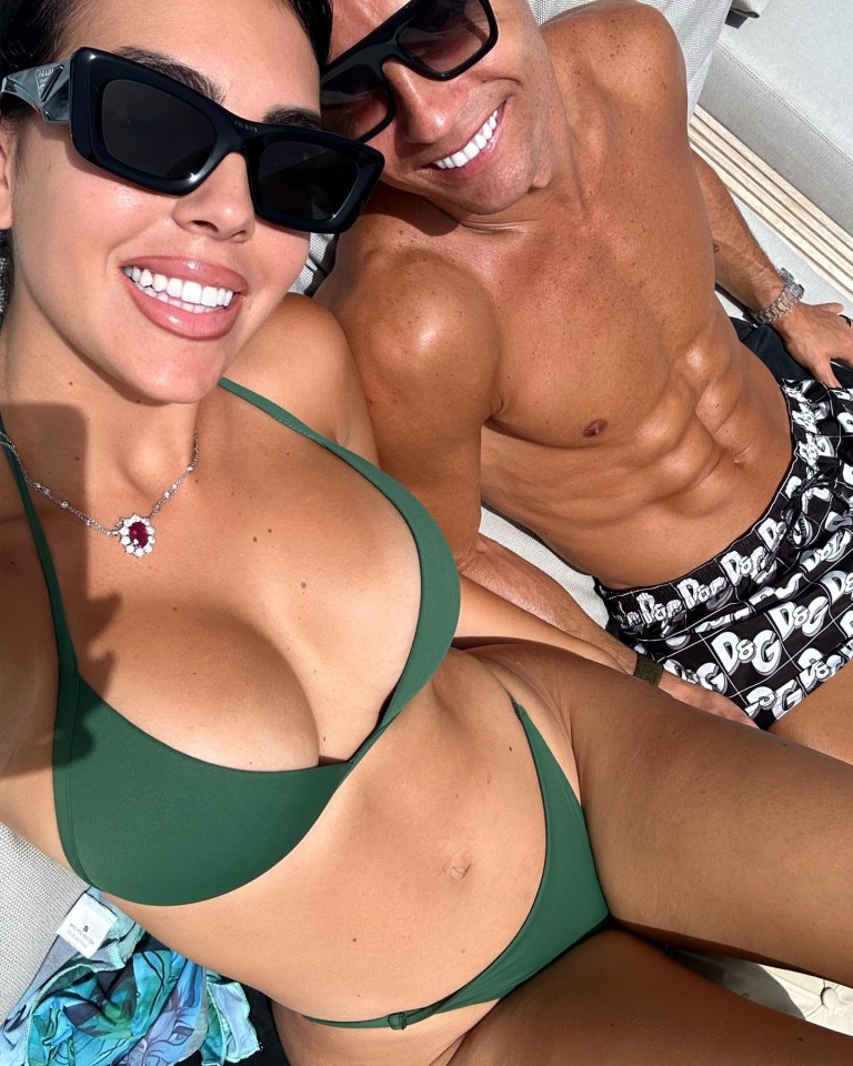 a man and a woman are posing for a picture and the woman is wearing a green bikini