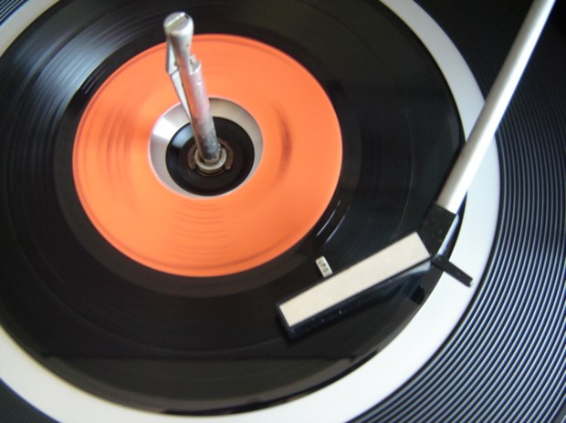 Record player needle on a red vinyl record.