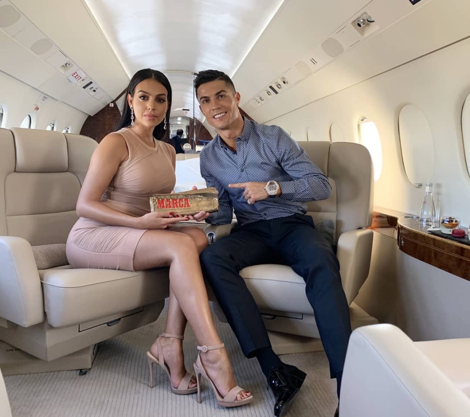 a man and woman are sitting on a plane and the man is pointing at something