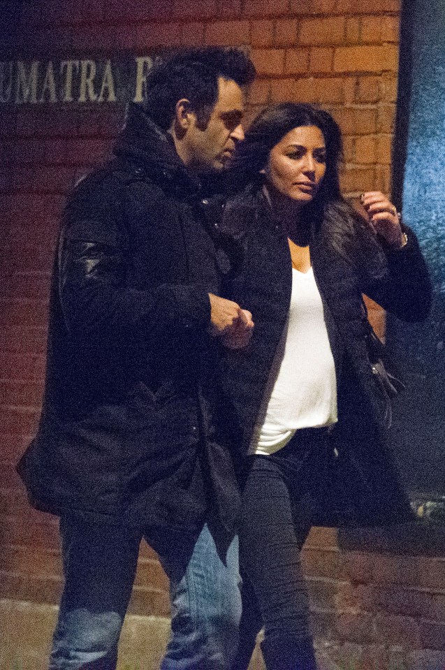 a man and woman are walking in front of a sign that says matra