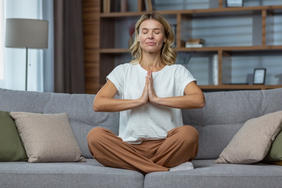 Woman meditating on a couch.