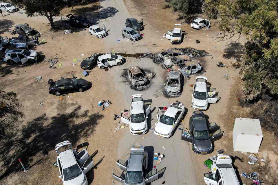 This aerial picture shows abandoned and torched vehicles at the site of the October 7 attack on the Supernova desert music Festival by Palestinian militants near Kibbutz Reim in the Negev desert in southern Israel on October 13, 2023. One month after Israel was wracked by Hamas attacks, life has been upended for both the Palestinians and Israel after it launched a war of reprisal in the Gaza Strip. The October 7 attacks by Hamas militants who stormed across from Gaza and struck kibbutzim and southern Israeli areas killed 1,400 people, mostly civilians, and deeply scarred the nation. The health ministry in Hamas-run Gaza says nearly 9,500 have been killed, two-thirds of them women and children, and mostly civilians. (Photo by Jack GUEZ / AFP) (Photo by JACK GUEZ/AFP via Getty Images)