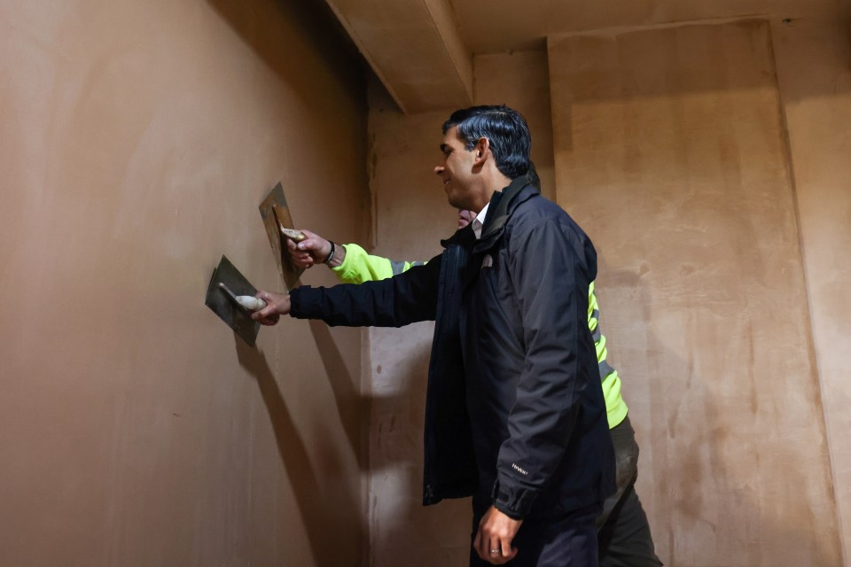 Prime Minister Rishi Sunak talks with trainees as he plasters a wall during a visit to the Construction Skills Village in Eastfield, Scarborough. Picture date: Thursday January 25, 2024. PA Photo. See PA story POLITICS Sunak. Photo credit should read: Darren Staples/PA Wire