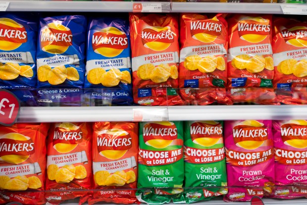 Supermarket shelf displaying multiple bags of Walkers crisps.