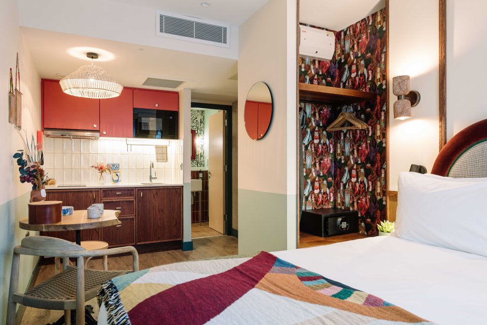 a hotel room with a bed and a small kitchen