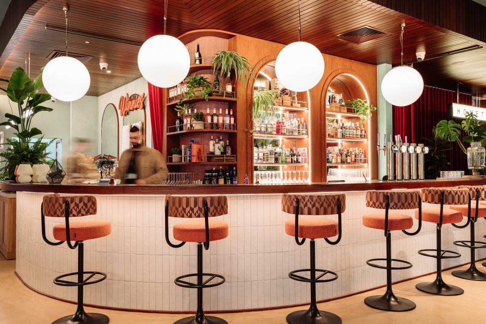 a man stands behind a bar with a sign that says waves