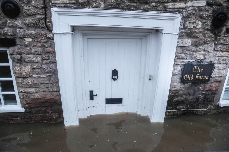 Water laps up against a home in deluged Croscombe, Somerset