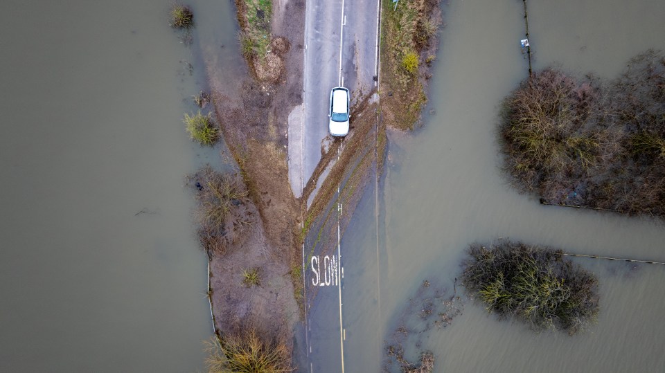 An aerial photograph captures the same car at the water's edge in Welney, Norfolk