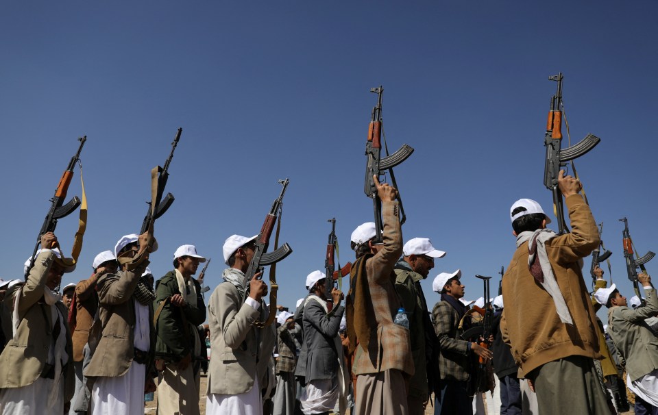 Armed Houthi followers hold up rifles during a protest decrying the US-led strikes on Houthi targets