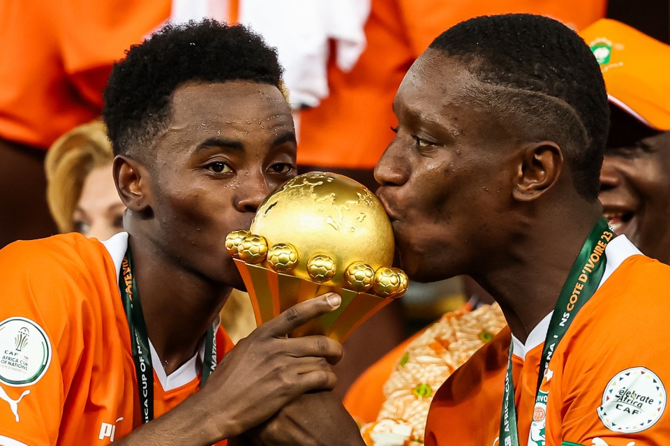 Ex-Leeds star Max Gradel (right) and striker Simon Adingra (left) kissing the trophy
