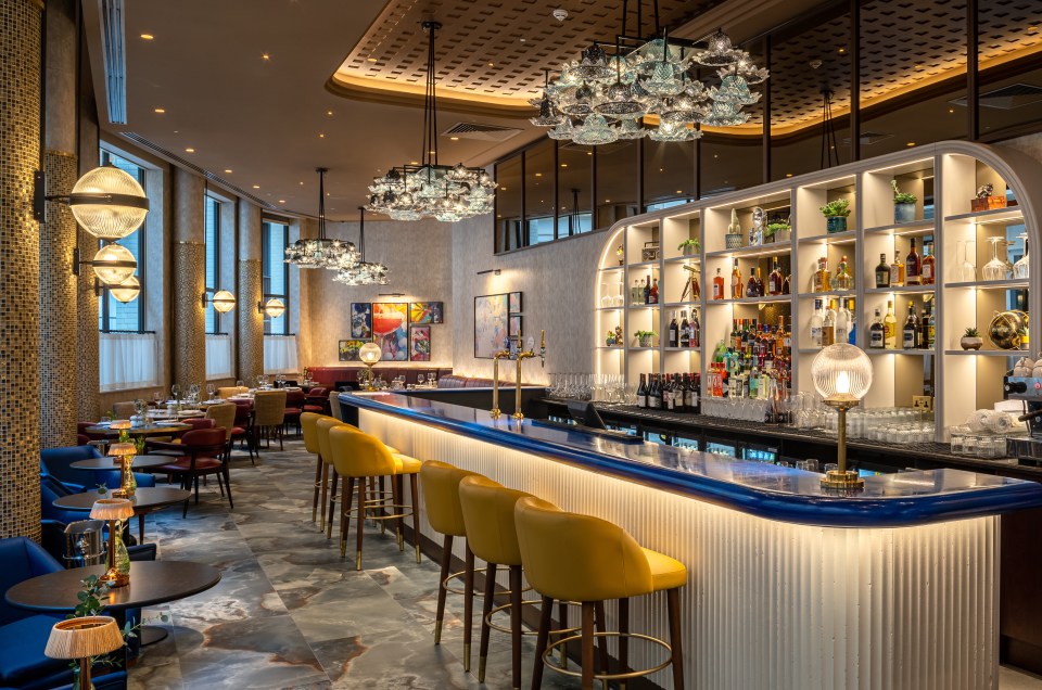 a bar in a restaurant with lots of bottles on shelves