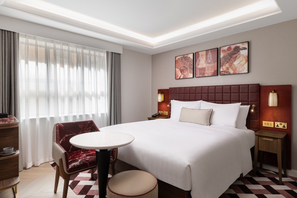 a hotel room with a bed a chair and a table
