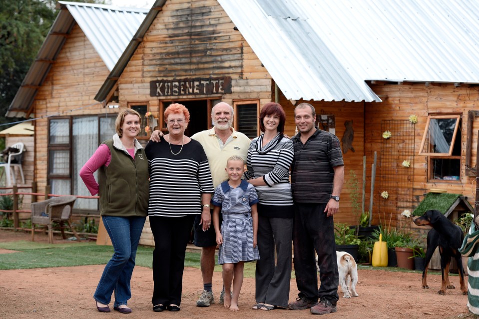 A family of residents outside their wooden home