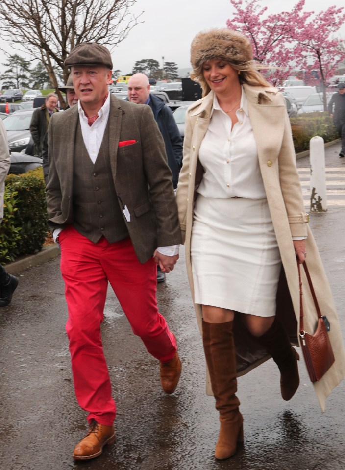 A well-dressed couple arrived hand-in-hand for their day of horse racing