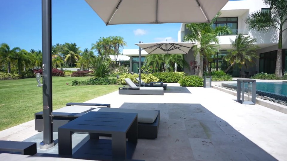 a patio with a table and chairs under an umbrella