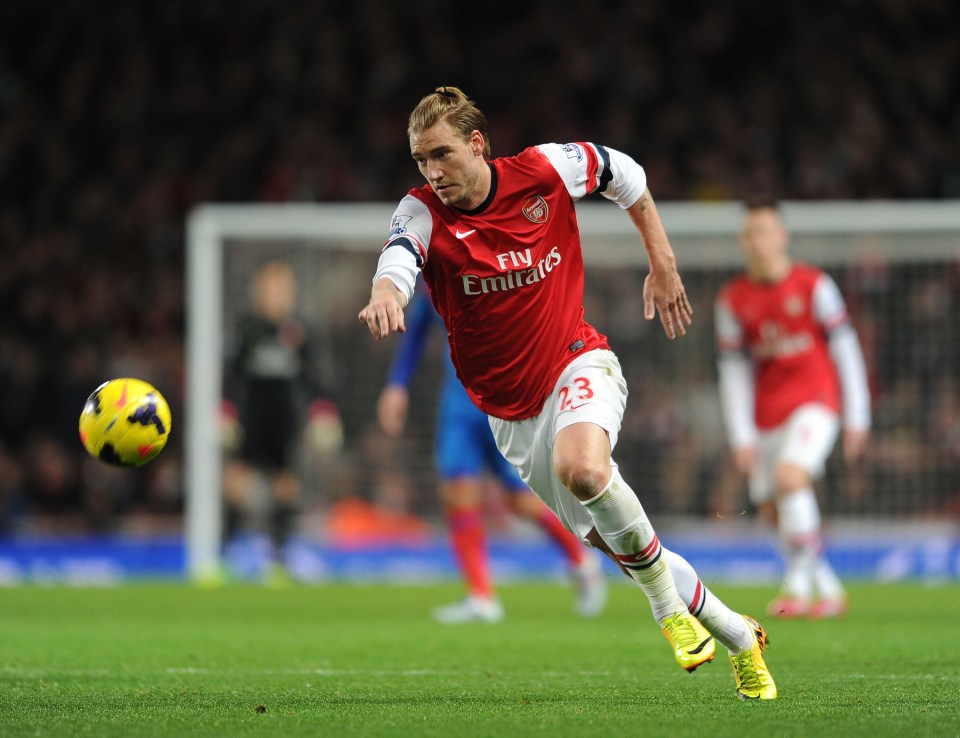 a soccer player wearing a fly emirates jersey kicks the ball