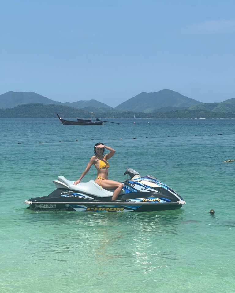 a woman in a bikini sits on a yamaha jet ski