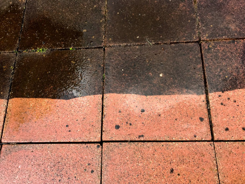 Before and after difference between the cleean and dirty parts of paving slabs on a pation after being pressure washed. No people. Copy space.