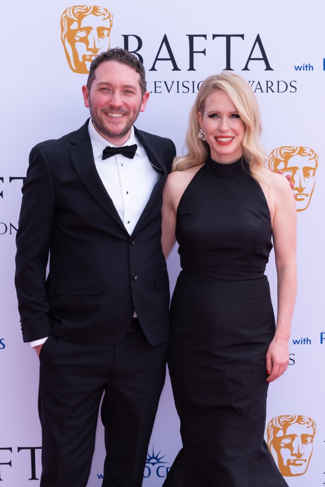 a man and woman pose for a photo in front of a wall that says bafta