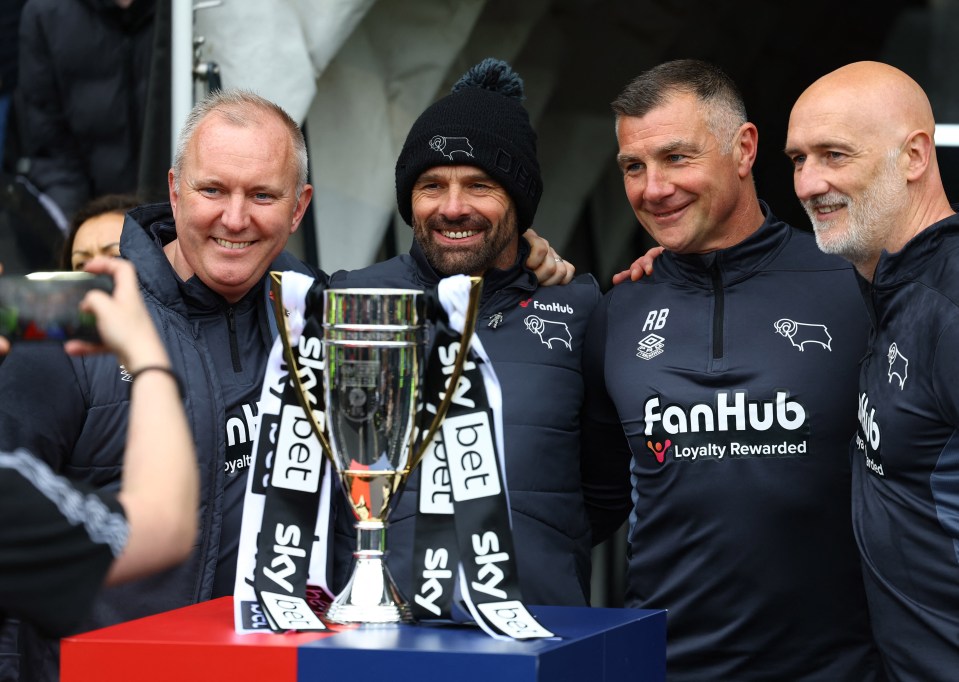 Soccer Football - League One - Derby County v Carlisle United - Pride Park, Derby, Britain - April 27, 2024 Derby County manager Paul Warne and his staff pose for a photo with the trophy after promoting to the Championship Action Images/Paul Childs NO USE WITH UNAUTHORIZED AUDIO, VIDEO, DATA, FIXTURE LISTS, CLUB/LEAGUE LOGOS OR 'LIVE' SERVICES. ONLINE IN-MATCH USE LIMITED TO 45 IMAGES, NO VIDEO EMULATION. NO USE IN BETTING, GAMES OR SINGLE CLUB/LEAGUE/PLAYER PUBLICATIONS.