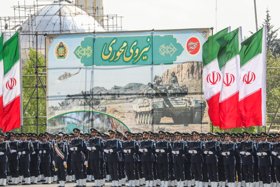 Iranian soldiers take part in a military parade today as they brandish drones and missiles