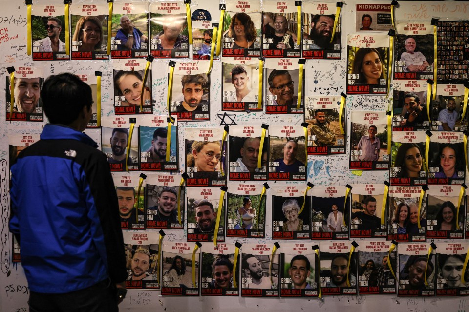 A man looks at posters with images of the Israeli hostages held in Gaza