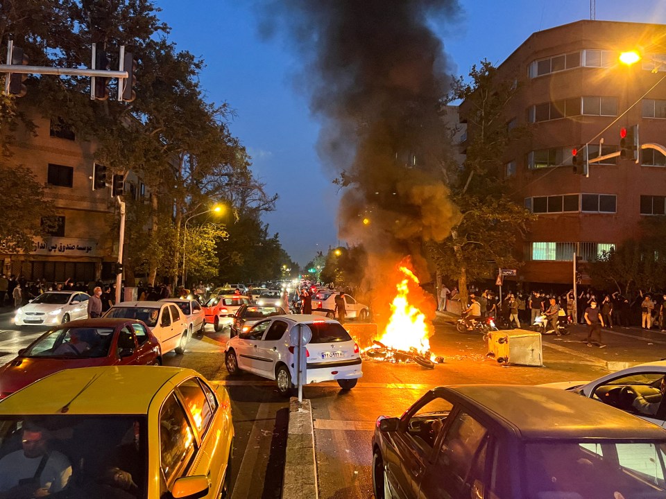 A cop motorcycle burns during a protest over the death of Mahsa Amini, a woman who died after being arrested by 'morality police' in Tehran, 2022