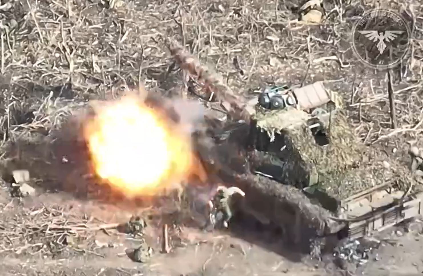 The first drone flies straight between two Russian soldiers and into the side of the tank