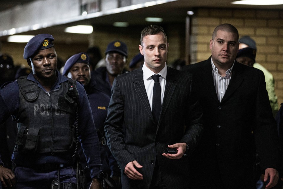 Pistorius (C) is surrounded by policemen as he arrives at Pretoria High Court in 2016