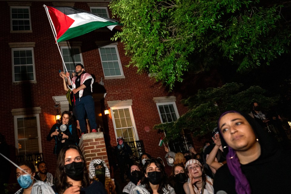 Pro-Palestinian demonstrators dance in the street near the George Washington University administrative offices