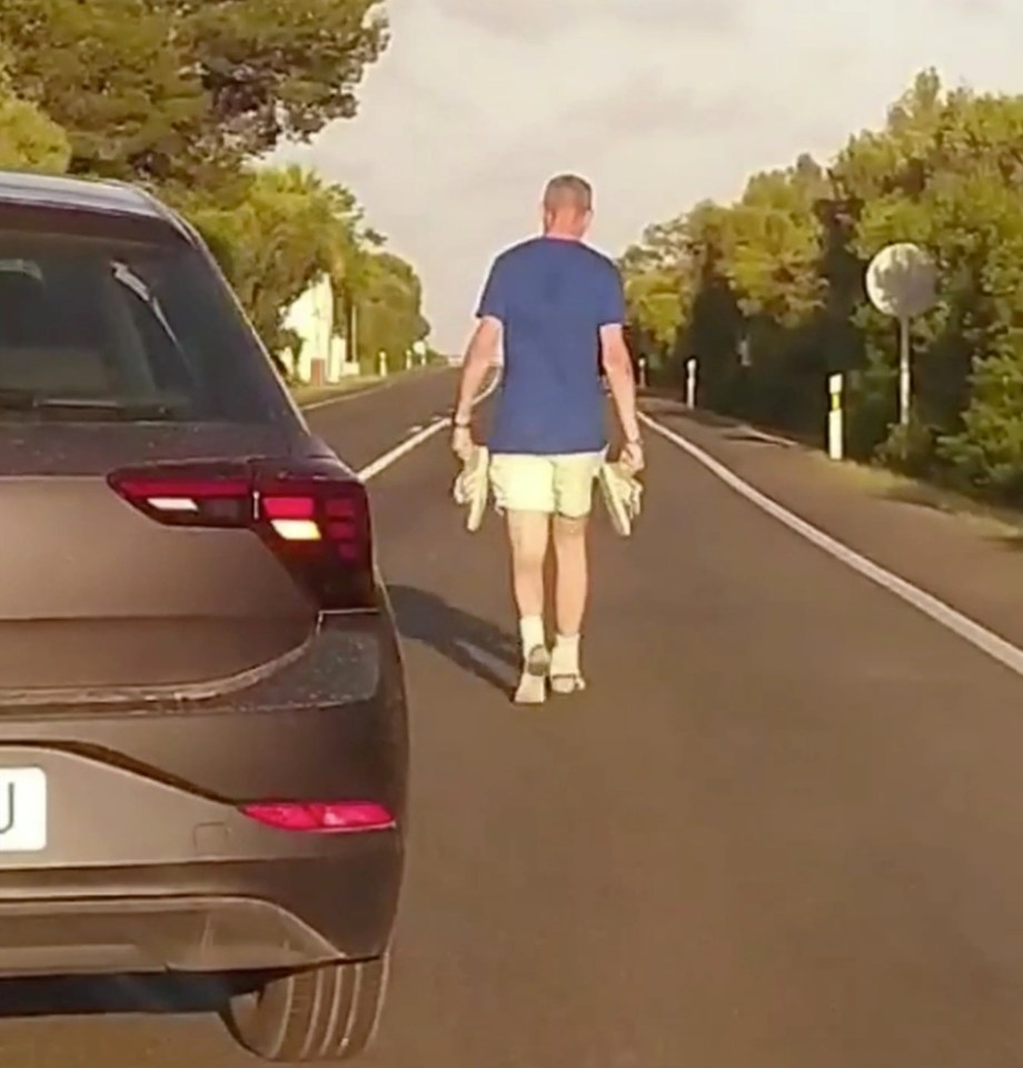 The drunk Brit was seen blocking traffic as he walked down a busy road with his trainers in his hands