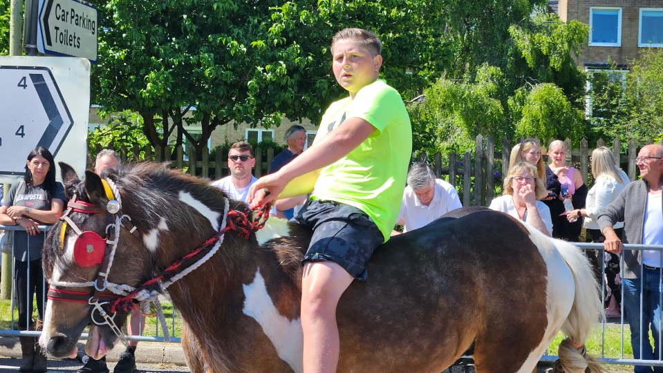 A boy rides a horse at the yearly fair