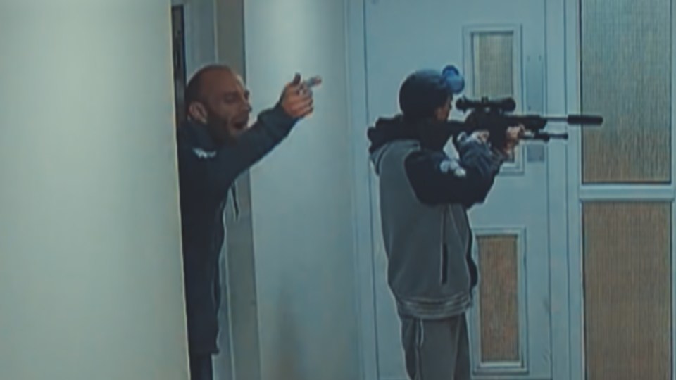 CCTV image of two men, one holding an air rifle.