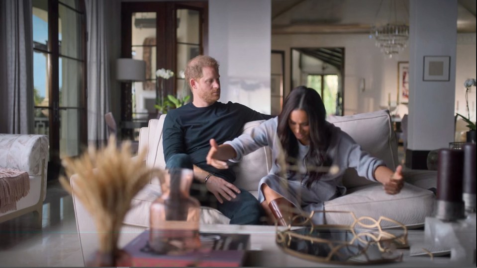 Prince Harry and Meghan Markle on a couch, discussing a meeting.