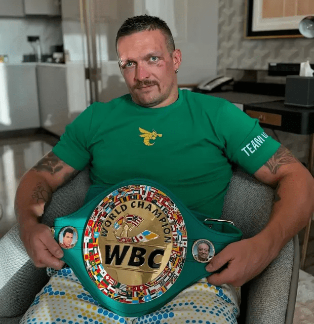 Usyk poses with the WBC belt he took off Fury