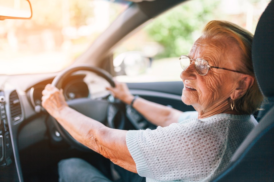 Elderly woman behind the steering wheel of a car