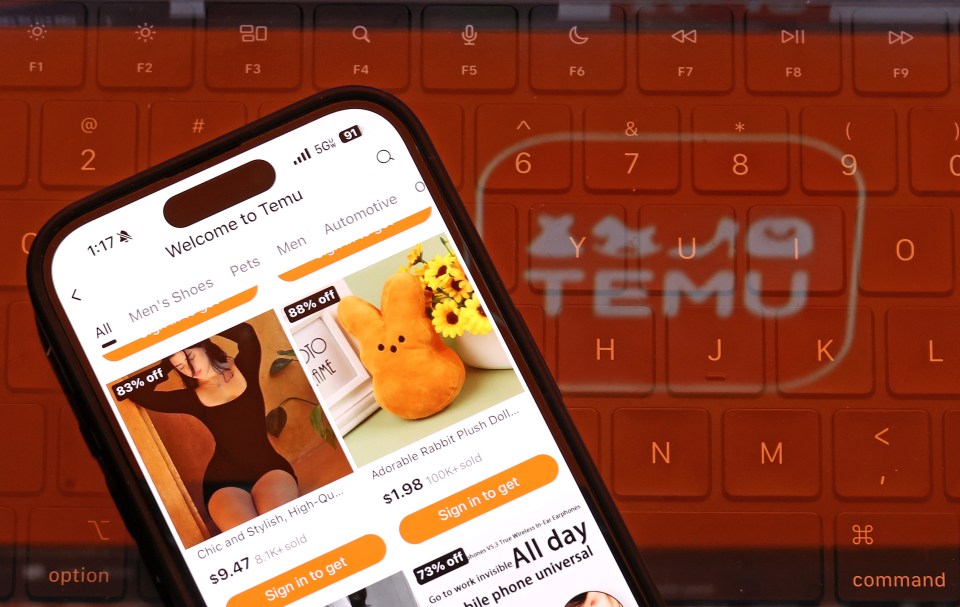Photo illustration of a smartphone displaying the Temu app on a laptop keyboard.