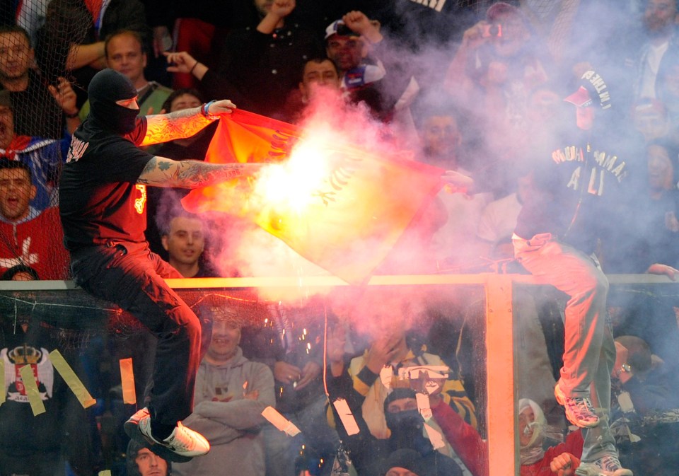 Serbian ultra groups are known for causing chaos at matches (Bogdanov) is pictured lighting flares in 2012)