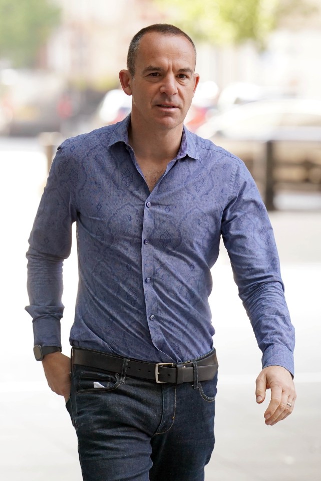 a man in a blue paisley shirt is walking down the street