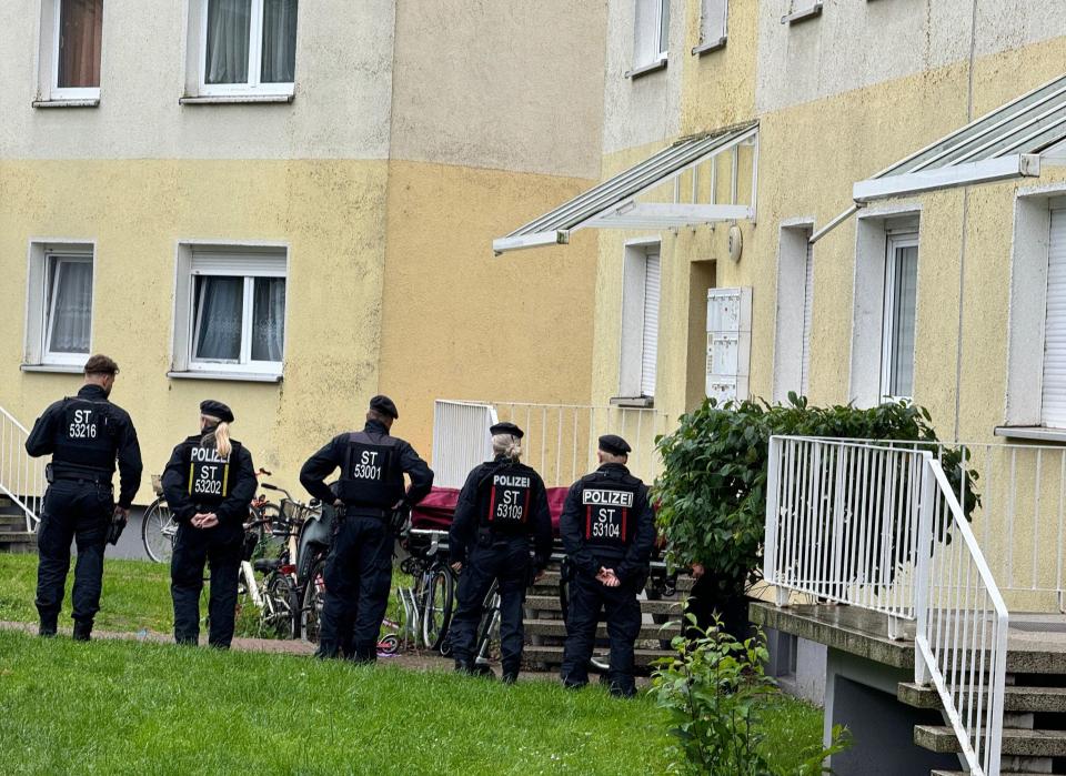 Police officers stand at a scene that may be connected to a stabbing attack in Wolmirstedt, Germany