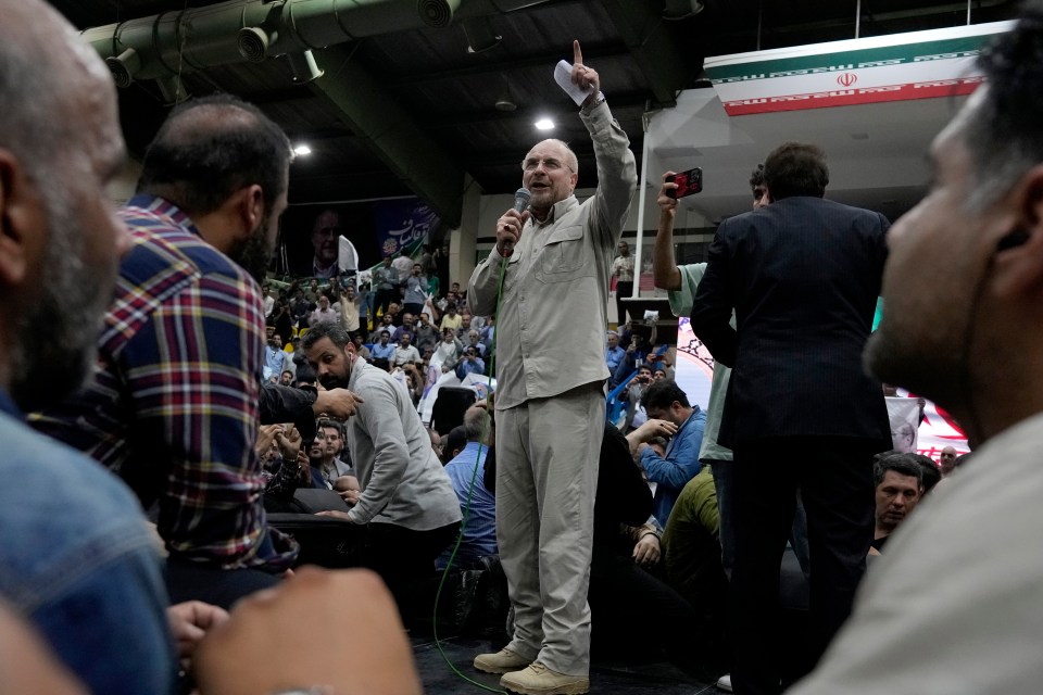 a man speaking into a microphone in front of a crowd