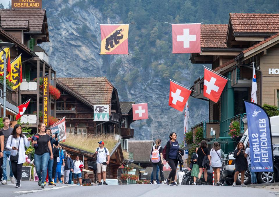 2RM8MFT Tourists walking in Lauterbrunnen village, Canton of Bern, Switzerland.