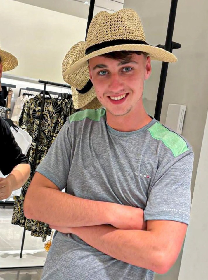 a young man wearing a tommy hilfiger t-shirt smiles with his arms crossed