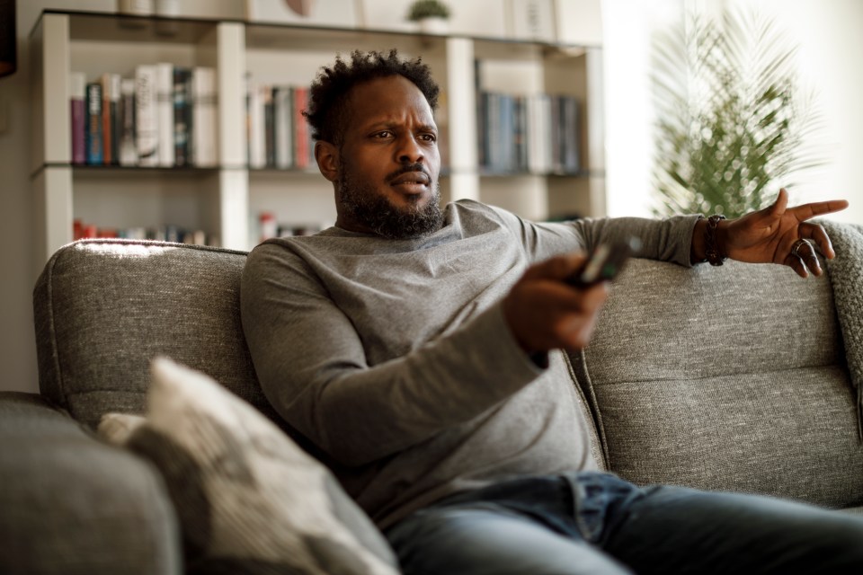 Angry man watching tv at home