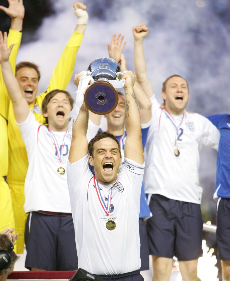 A triumphant Robbie lifts the cup for England