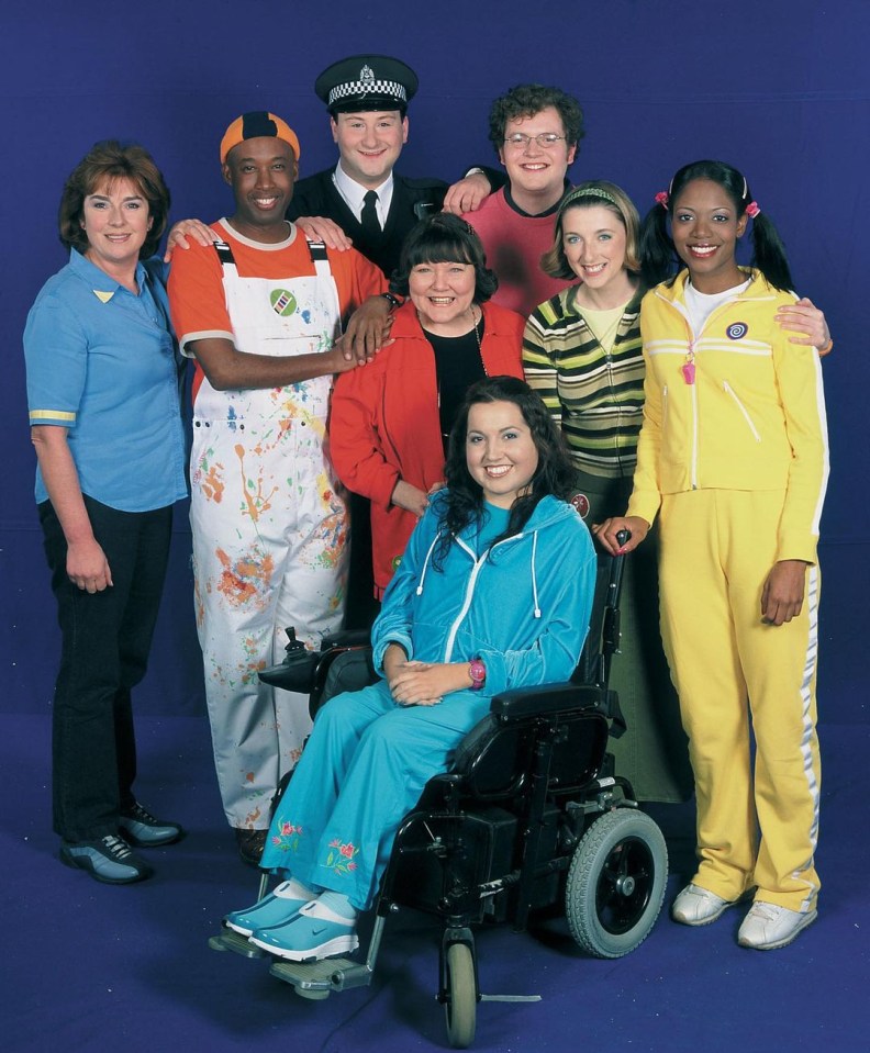 a woman in a wheelchair is surrounded by a group of people