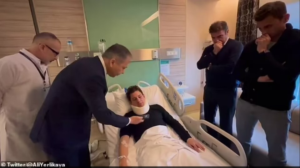 a group of men are standing around a man in a hospital bed