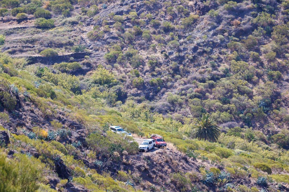 a few cars are parked on the side of a hill
