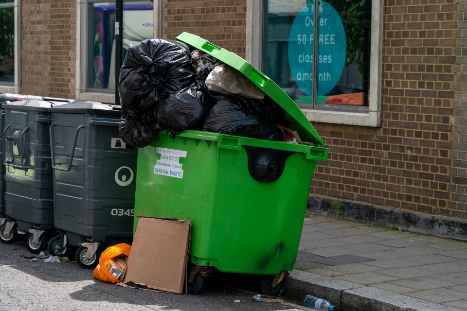 a green trash can has a sign on it that says general waste
