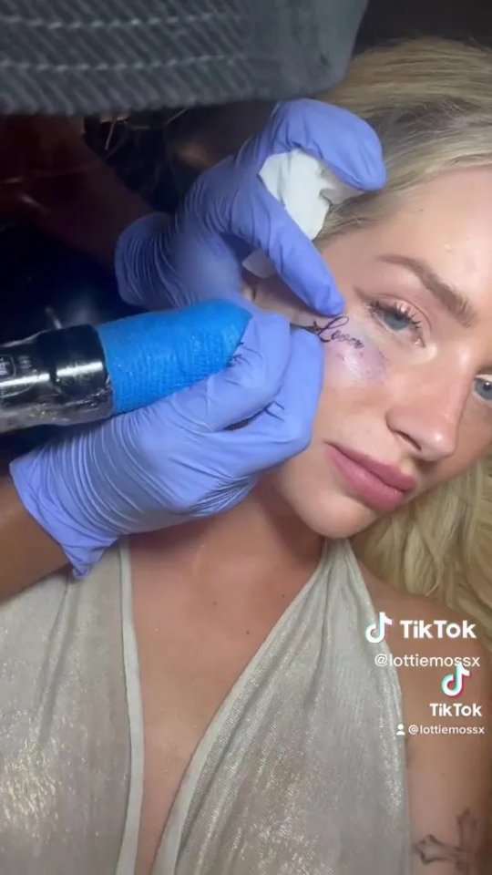 Lottie Moss getting a "Lover" tattoo under her eye.